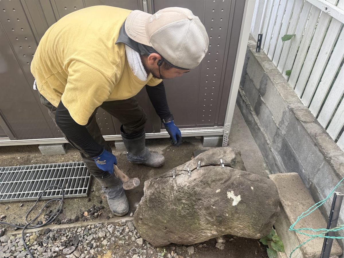 セリ矢を入れた庭石をハンマーで割る作業